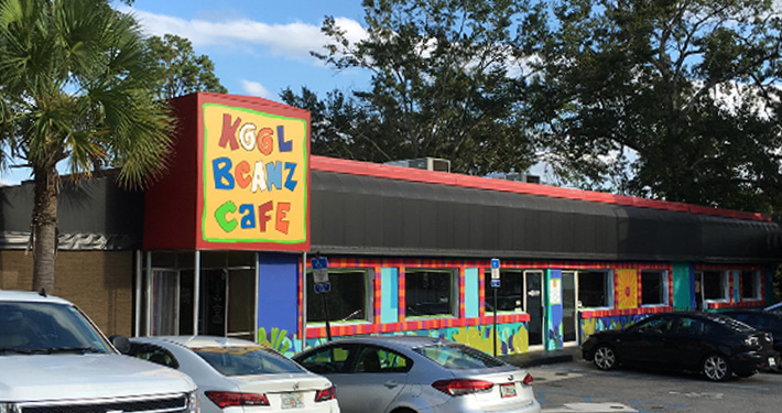 The hand-painted Kool Beanz Cafe sign above a low red and turquoise building on Thomasville Road.