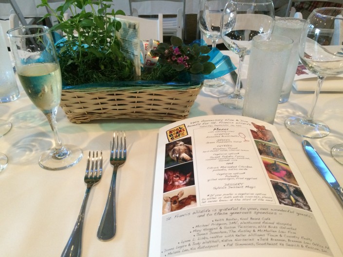 A place setting in The Room with a printed custom menu, wine glass and a basket of fresh herbs as a centrepiece.